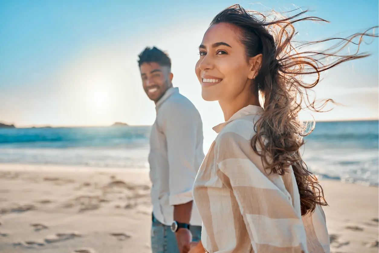 New Project(6) Couple smiling and walking on the beach.